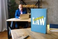 Lawyer holds LABOUR LAW book. Labour lawÃÂ mediates the relationship between workers, employing entities, trade unions and the